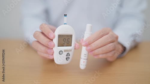 Hand checking Diabetes or Blood glucose self testing by digital blood glucose meter with lancet pen. high blood sugar level, World Diabetes Day, Glycemia, Hypoglycemia, Hyperglycemia and insulin