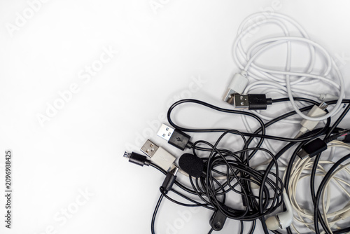 tangled cables and wires on a white background, showcasing various types of connection cables for electronics and accessories.