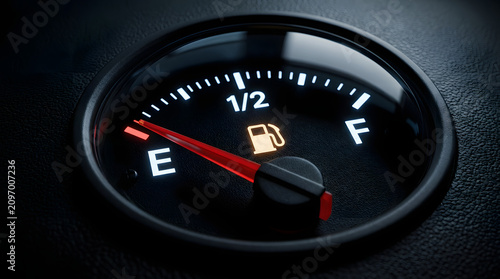Close-up of car fuel gauge with low gas warning light on dashboard in vehicle