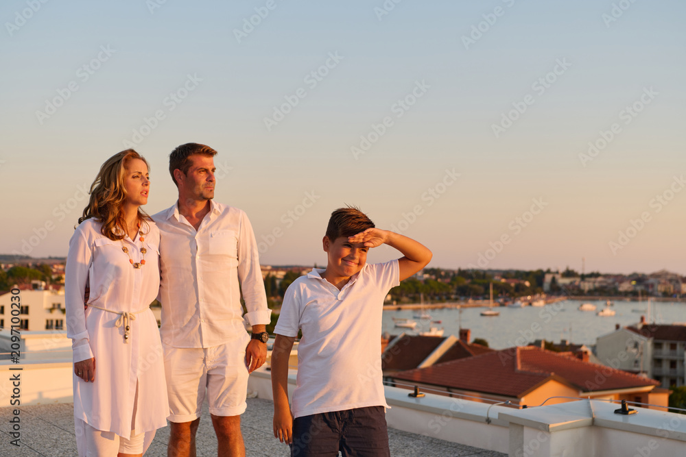 Obraz premium Family on Rooftop Terrace Overlooking Sea at Sunset in Umag, Croatia