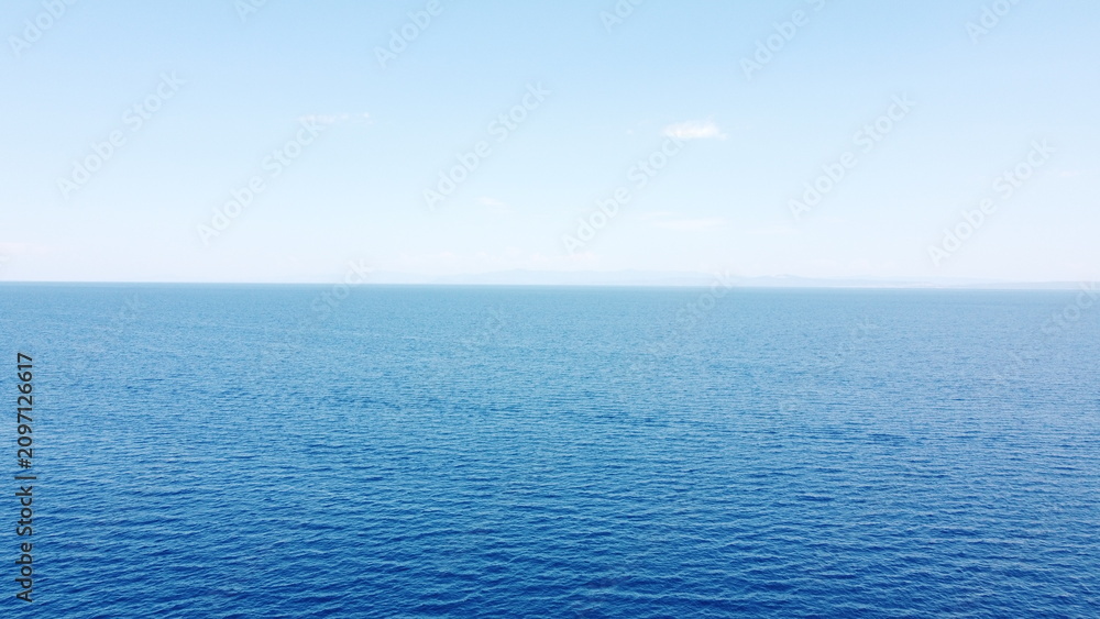 Fototapeta premium Aerial drone view of turquoise and deep blue ocean water gradient under clear blue sky