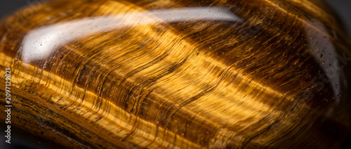 Quadro em tela Close-up of polished tiger's eye gemstone, showcasing distinct golden-brown fibr