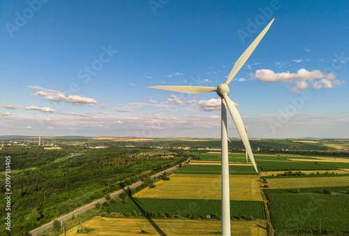 Wind turbine standing in green agricultural field, renewable energy production and sustainable industrial power concept