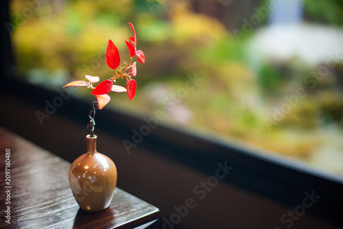 A Japanese vase with red leaves creates a warm and inviting atmosphere.