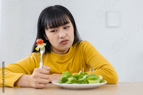 Tableau sur toile Unhappy Asian woman with disgusting face feeling bored with healthy food