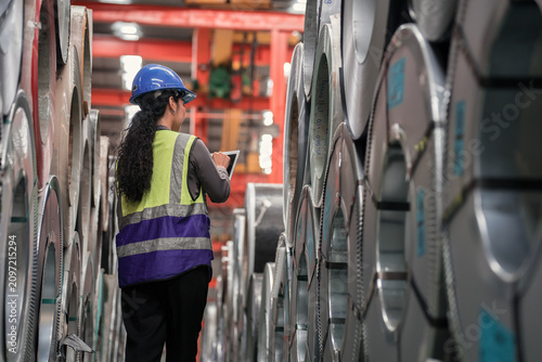 Industrial Technician Inspecting Steel Rolls in Manufacturing Plant