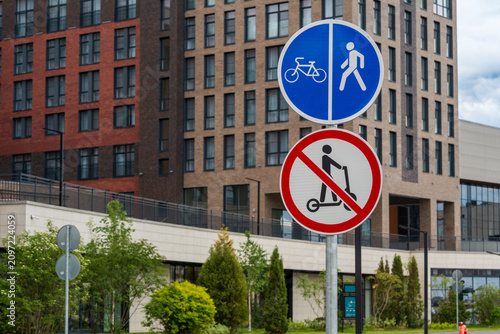 Konstfotografi Road signs indicating a shared pedestrian and bicycle path with electric scooter prohibition in a modern residential district, highlighting urban mobility regulations, traffic safety