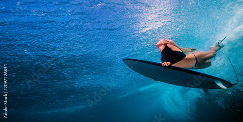 Underwater Action Shot of Female Surfer Paddling in Turquoise Ocean Waters
