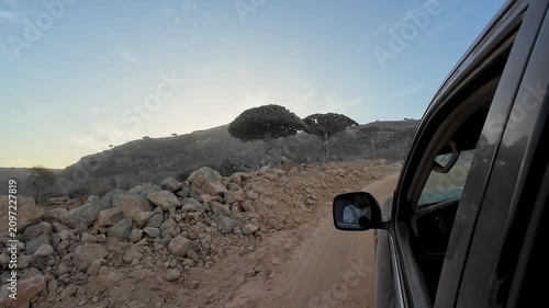 Car on a dirt road in dry rocky hills. Socotra, Yemen.
