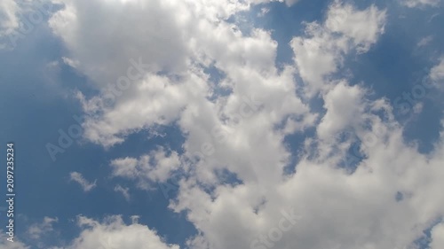 Dynamic time-lapse video showing bright white cumulus clouds moving fast and converging to cover a clear blue sky. Perfect for weather transitions and time passing concepts.