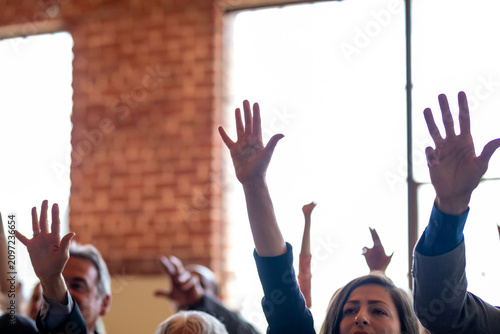Hands raised in group meeting.
