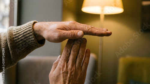 Man showing time out gesture with hands against a blurred indoor background, signifying a break or pause in a discussion or activity.