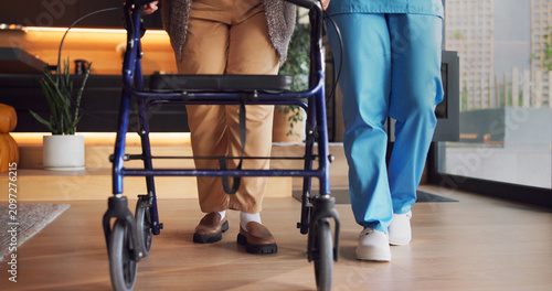 Obraz na plátne Legs, rehabilitation and walker with people in clinic together for balance or stability