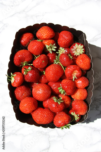Canvastavla Sunlit Fresh Strawberries Packed in a Dark Scalloped Punnet on Marble