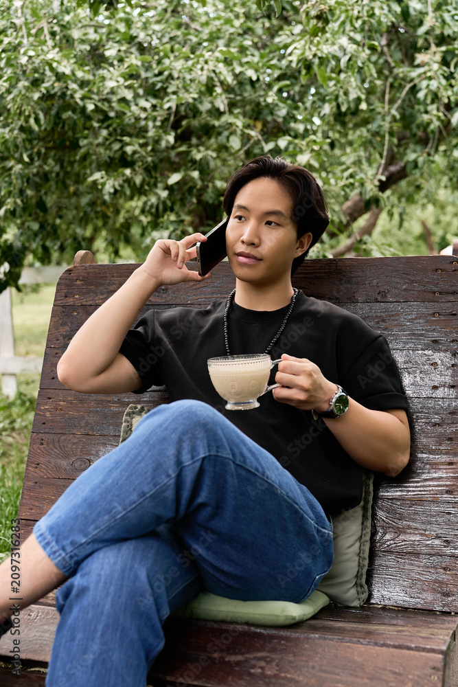 Obraz premium Relaxing summer day at a garden cafe with a young man enjoying casual vibes