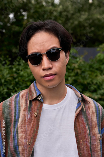 Young man enjoys a sunny cafe day amid greenery and relaxation