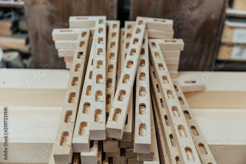 Fotografía Close-up of stacked narrow wooden rails featuring repeated routed mortise slots
