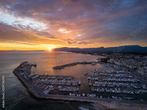 Aerial Sunset Over Marina and Harbour With Docked Yachts Along Coastal Town Shoreline, Cambrils, Spain