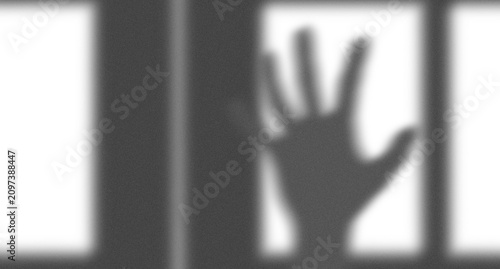 Photos Shadow of a human hand reaching out from behind iron prison bars representing ca