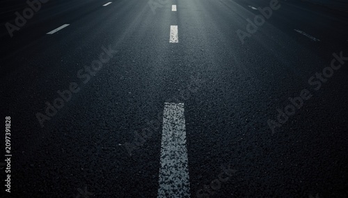 Closeup of Empty Asphalt Road with Painted Lane Markings and Dim Light