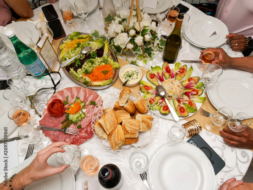Fototapeta premium Colorful wedding buffet with fresh salads, rice, avocado appetizers and rustic bread on an elegantly decorated reception table