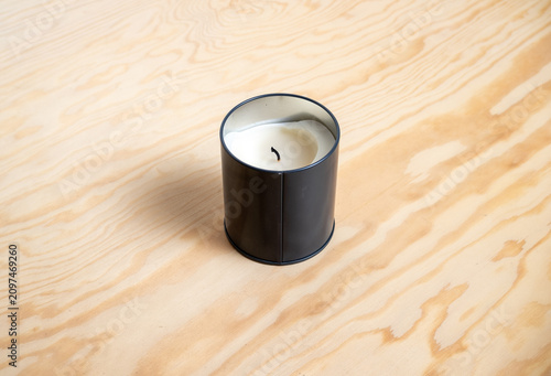 Tableau sur toile Black tin candle with melted wax and wick on wooden table