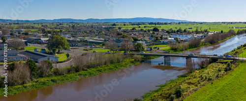 Bild auf Leinwand Aerial view of the Paiko River flowing through farmland and the small town of Ngatea, New Zealand