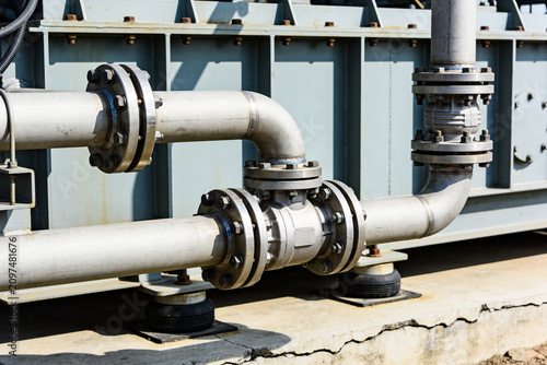 Billede på lærred Industrial piping system with valves and flanges on a sunny day