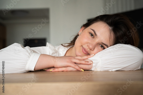Woman resting her head on desk in home office setting. Remote work fatigue and deadline stress in a domestic workspace