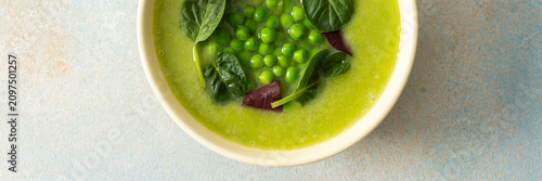Fotografie Bright green soup made with broccoli and green peas sits in a bowl