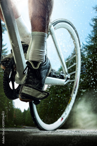 Картината върху платно Low-angle view of cyclist foot clipped into pedal with road bicycle under bright sunlight