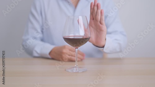 man making stop hand gesture to refuse a glass of Wine, Healthy man say no to alcohol drink, stop alcoholism and addiction concept. Responsible man reject a drink before driving and quit booze