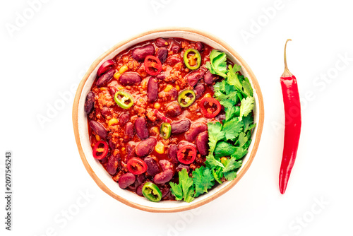 Chili con carne in ceramic bowl, isolated on white background, overhead flat lay shot with a red pepper