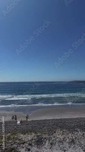 Ocean Waves Breaking on a Sandy Beach Under Clear Blue Sky