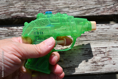 Green water pistol in hand