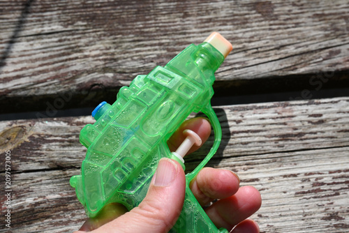 Green water pistol in hand