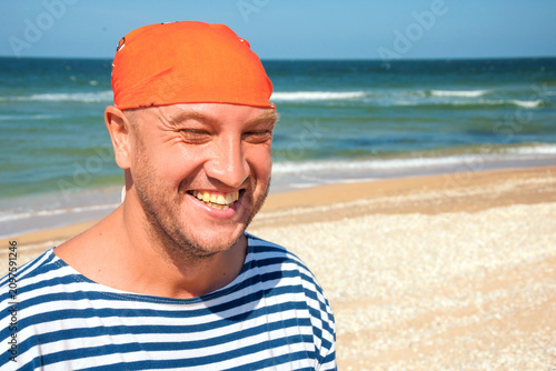 Photos Caucasian Bald Man Laughing in Striped Sailor Shirt and Orange Bandana on Sandy