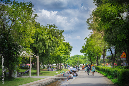 People cooling off and playing in an artificial stream at Yeouido Hangang Park on a hot summer day, Seoul, South Korea 