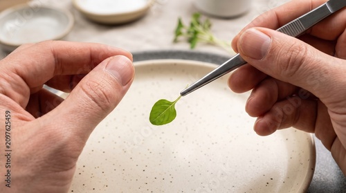 Precision in Culinary Arts: Hand Holding Fresh Leaf with Tweezers for Plating