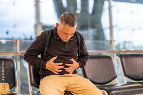 Foto Senior asian elderly man sick unhappy touching belly stomach with suffering from