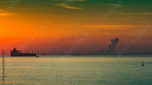 Fotografie Industrial pollution creating dramatic sunset over fos-sur-mer