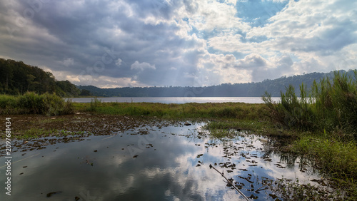 Obraz na płótnie Scenic View of Lake Buyan with Sunbeams and Dramatic Sky Reflection, Bali