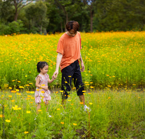 Mother and daughter walking hand in hand at spring park, moment of family bonding and togetherness. outdoor activitie. Asian Family with father mother daughter and grandfather