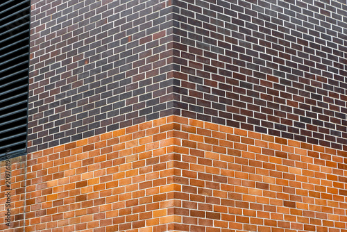 Corner view of two different colors of brick wall.