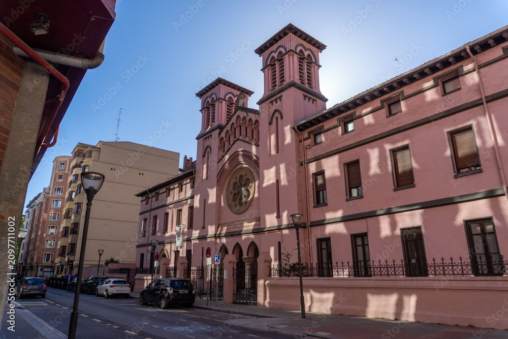 Fototapeta premium Pink church building with ornate facade and towers on a sunny day