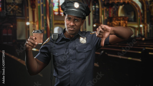 Konstfotografi Man police officer in uniform holding takeaway coffee cup, peering at the lid inside a church building with pews and stained glass; suspicion caution inspection