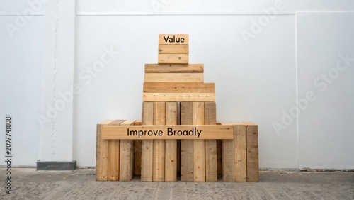 Wooden blocks stacked with messages of value and improvement on a simple background in a modern minimalistic setting