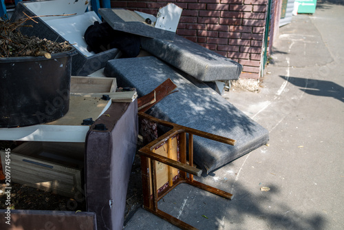 Принти на полотні Discarded old furniture and bulky waste piled up on a city sidewalk