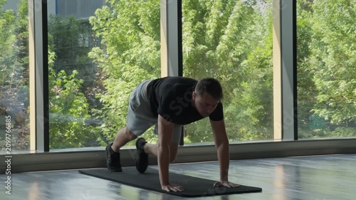 Man doing mountain climber exercise on mat indoors
