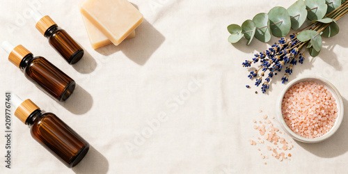Premium Flat Lay of Natural Herbal Skincare Products with Botanical Soaps, Amber Serum Bottles, Bath Salts, and Fresh Greenery on Soft Pastel Background for Clean Beauty and Wellness Branding